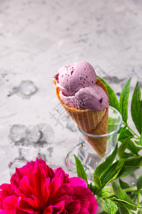 明亮的白莓粉红冰淇淋在松饼锥盘上在灰图片