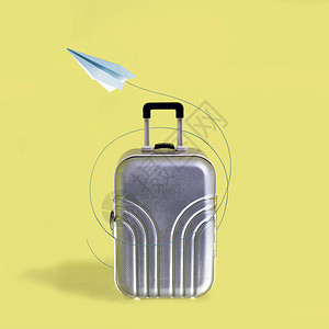 银色旅行手提箱和纸飞机图片