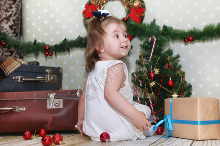 小女孩坐在圣诞树前玩具图片