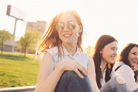 一群快乐的年轻女孩朋友享受夏季城市街道日落背景的生图片