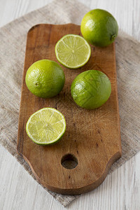 整块绿色柑橘柠檬在铁制木板上切开白色木图片