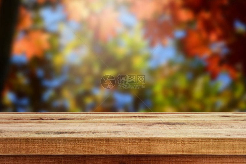 木桌和模糊的秋天森林背景图片