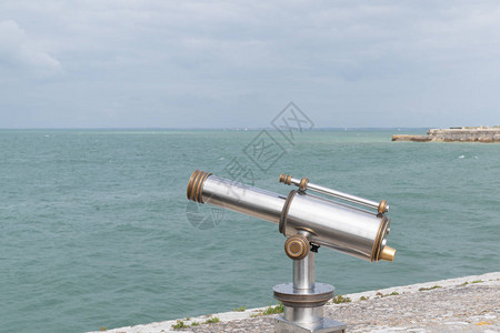 为观光游客操作的望远镜观看海滨图片