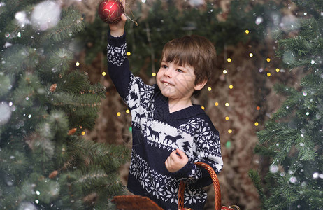 新年树旁的小孩圣诞树上装饰图片