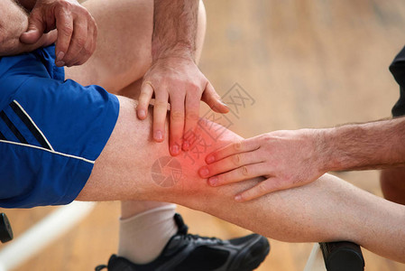 健身俱乐部的损伤健身教练帮助在体育活动中膝盖受伤的人培图片