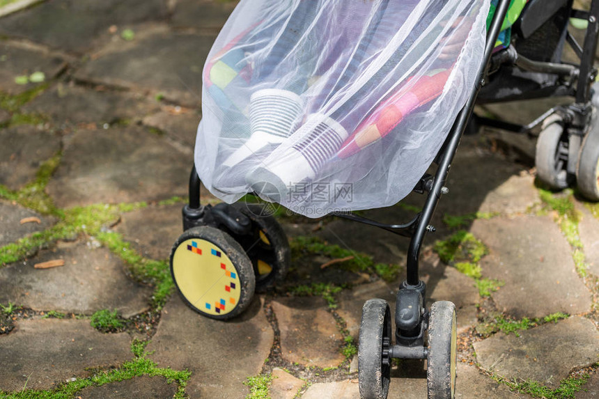 婴儿车里的孩子在时覆盖着防护网带防蚊白色罩的婴儿车在户外步行季节为儿童图片