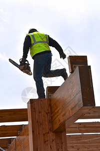 一名建筑工人在拆除一栋建筑物时用锯链切图片