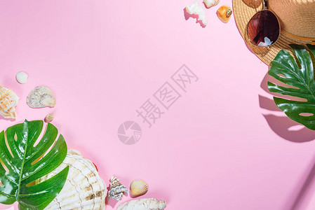 沙滩配饰帽太阳镜海星沙滩帽和粉色纸背景上的贝壳图片