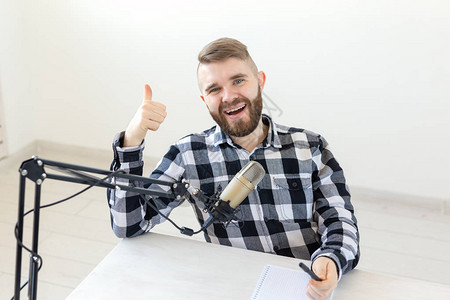 电台主持人流光和博主的概念微笑的男人竖起大拇指在电台或他的博客主图片