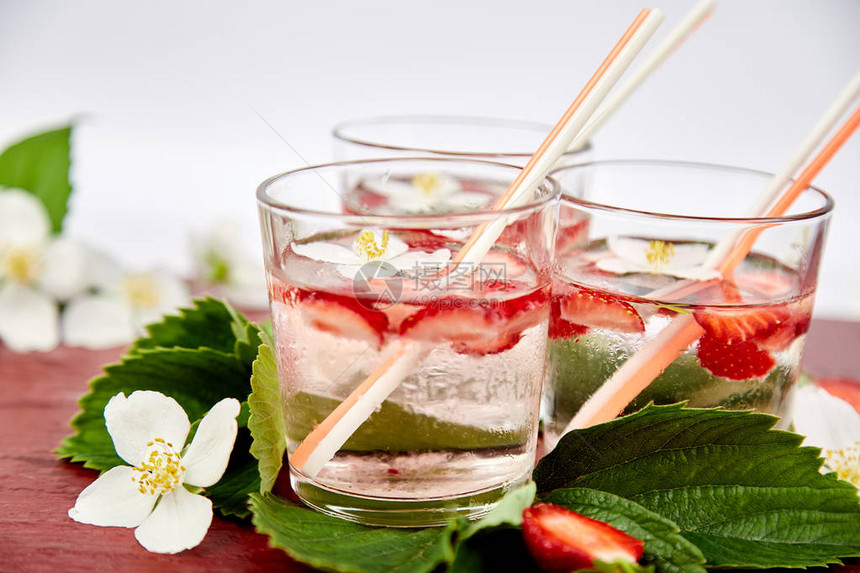 茉莉花草莓排毒水夏季冰镇饮料或茶柠檬水配浆果新鲜草莓玻璃杯中的图片