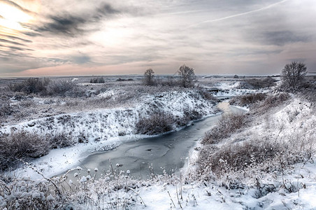 冬季日出落时被新雪覆盖的河流景观图片