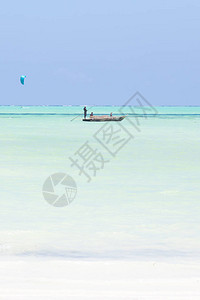 独立渔船和风筝冲浪手在图画完美的白沙滩上图片
