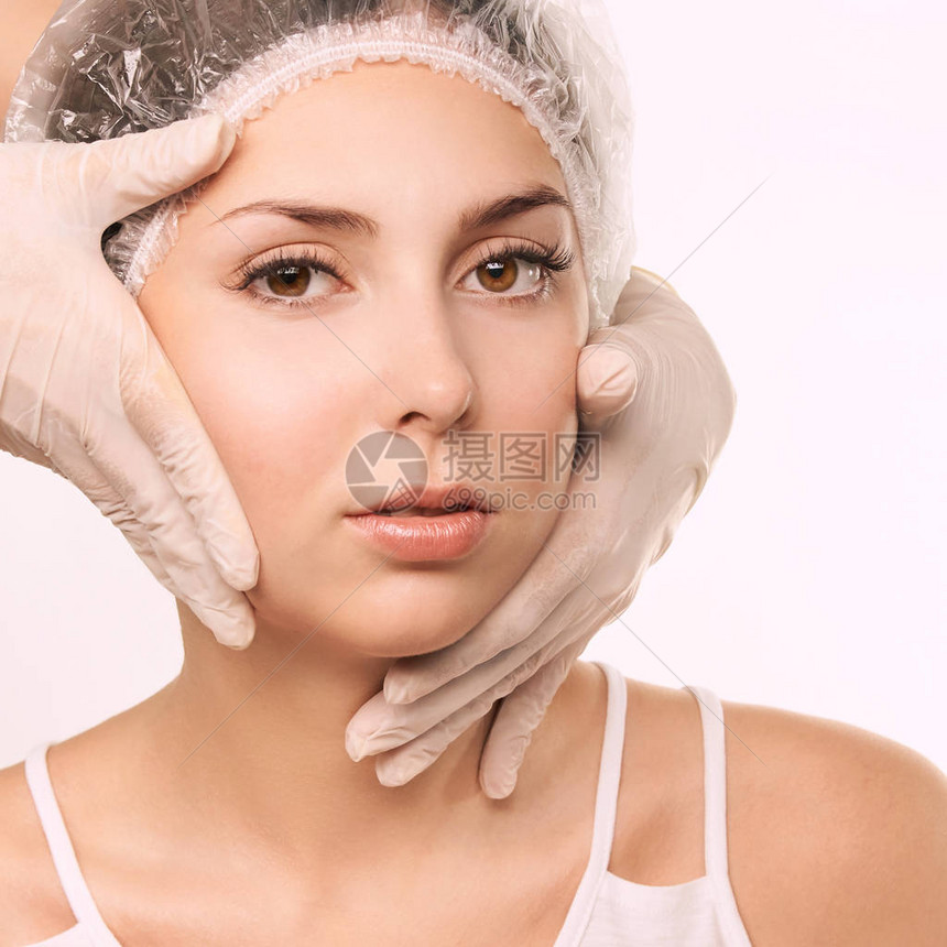 女皮肤恢复治疗手套医生触摸妇女的脸部美容学肖像画面部注射病人图片