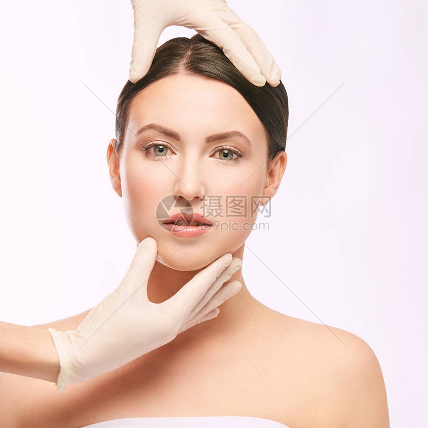 女皮肤恢复治疗手套医生触摸妇女的脸部美容学肖像画面部注射病人图片