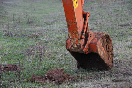 用铲斗挖地的挖掘机图片
