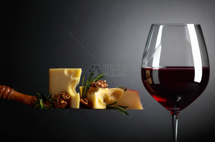 带核桃迷迭香和红葡萄酒的乳酪深色背图片
