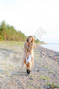 金发美女站在海边穿着白裙子穿大衣快乐青春和时尚的概念暑假图片