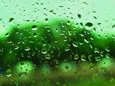 汽车玻璃绿色背景上的雨滴图片