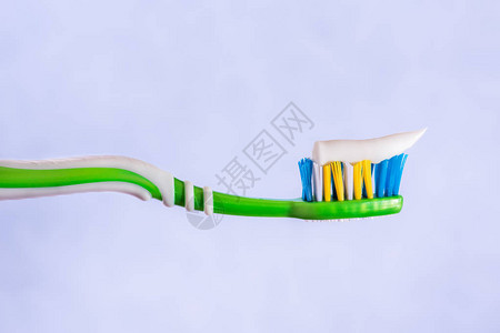 牙刷挤在牙刷膏蓝色背景上图片