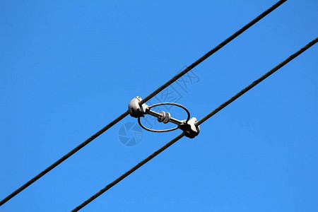 两根电力线公用黑色电线在清澈的蓝天背景上与强绝缘体和隔离图片