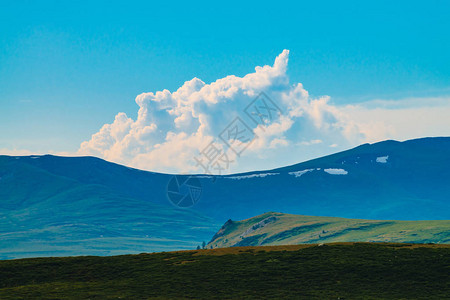 巨大的山脉与雪的壮观景色山上的巨大云深渊之上的大岩石峭壁美妙的野生风景大气雄伟的自然高原景观风背景图片