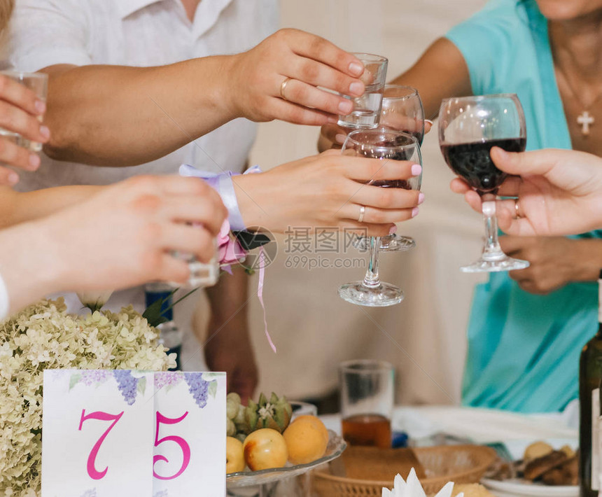 一群朋友的手碰着酒杯敬酒和祝贺在一家餐厅的一个节图片