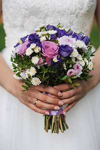 新娘近亲手握着带有粉红玫瑰和白菊图片