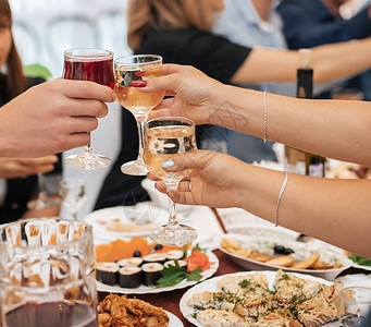 一群朋友的手碰着酒杯敬酒和祝贺在一家餐厅的一个节图片
