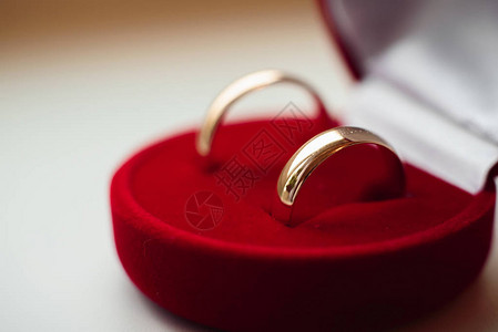一对金婚戒指躺在一个传统的红色图片