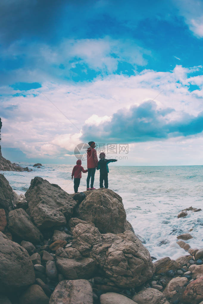 一个带着儿子的女人站在一块石头上图片