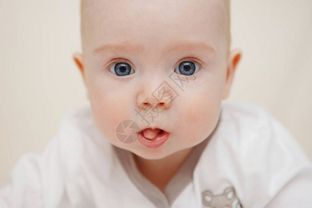 美丽的五个月大的蓝眼睛女婴趴在她的肚子上图片