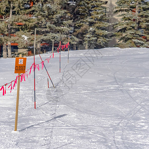 封闭的标志和路障对着帕克城厚的积雪覆盖的地面背景中可以看到建筑物前图片