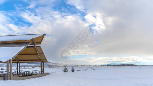 全景广阔的风景在冬天在多云的蓝天下被雪覆盖在雪顶亭内可以看图片