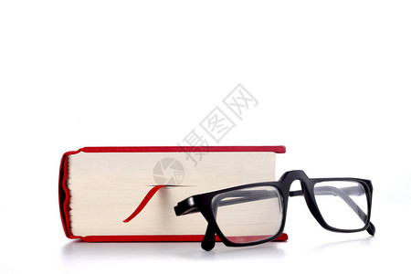 在白背景上隔离的红色书和眼镜并有文图片