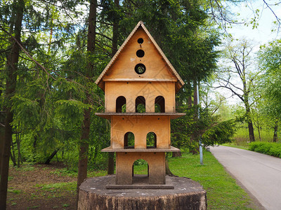 树桩上的多层木制雕小鸟屋公图片