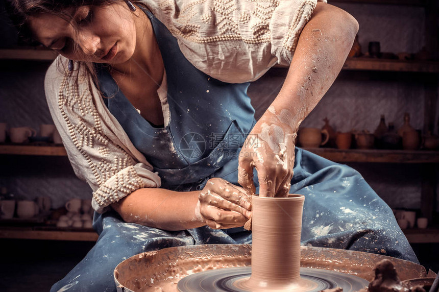 在陶瓷车间做陶器工作的时髦的女学生陶图片