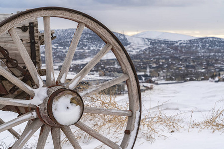 在冬天观看的老式推车的生锈金属木轮图片