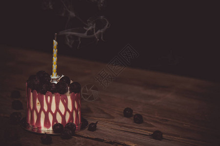 节日蛋糕上的一根熄灭的蜡烛图片