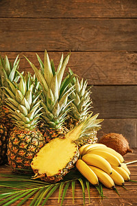 木制背景上的成熟菠萝香蕉和椰子图片