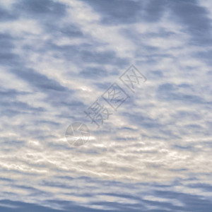 方正的无边际的蓝天布满了一层白色的蓬松的云彩在冬季抬头看散焦图片