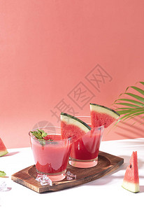 红色背景上的新鲜西瓜汁和西瓜片图片