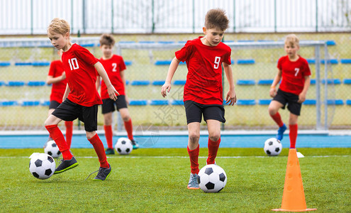 男孩在草场上训练足球技能儿童图片