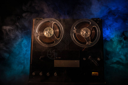 开盘在即旧的老式卷轴到卷轴播放器和录音机在深色调的雾背景上带卷盘的模拟立体声开盘式录音机播放器背景