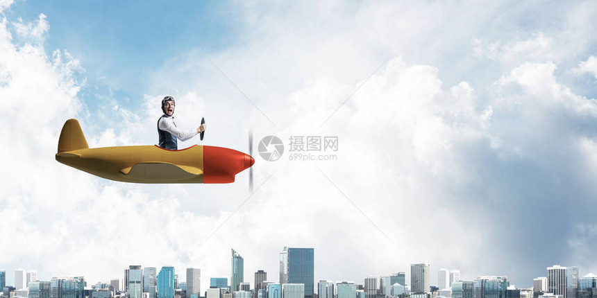 飞行员坐在小型飞机舱内的商业方向和动机概念戴着飞行员帽和护目镜在城市上空驾驶螺旋桨飞机的滑稽人高楼林立图片