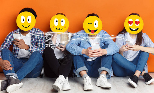 使用智能手机和社交网络聊天橙色背景的具有正面民主图标的少年人图片