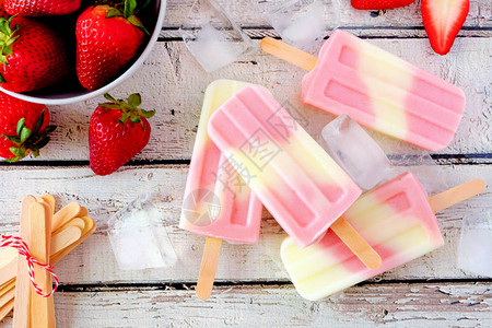 健康草莓酸奶夏季冰棒在白木背景下图片