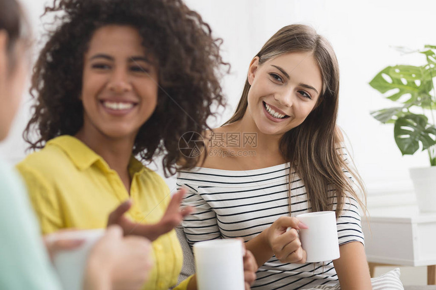 快乐的室友们喝咖啡和在家客厅友好交谈图片