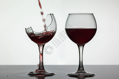 红酒倒入湿面破碎的葡萄酒杯中图片