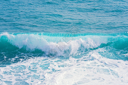 近距离观察美丽的蓝色海平面滚动波以及喷洒和泡沫的飞溅和泡沫夏季背景纹图片