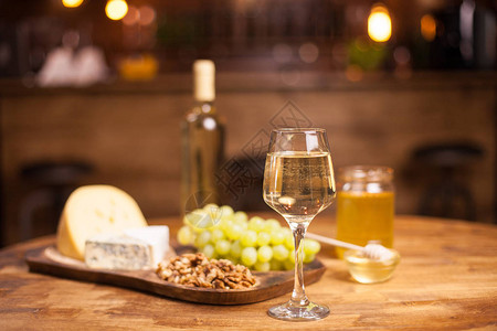 旧木桌上的白葡萄酒奶酪和葡萄美味的葡萄好饮背景图片